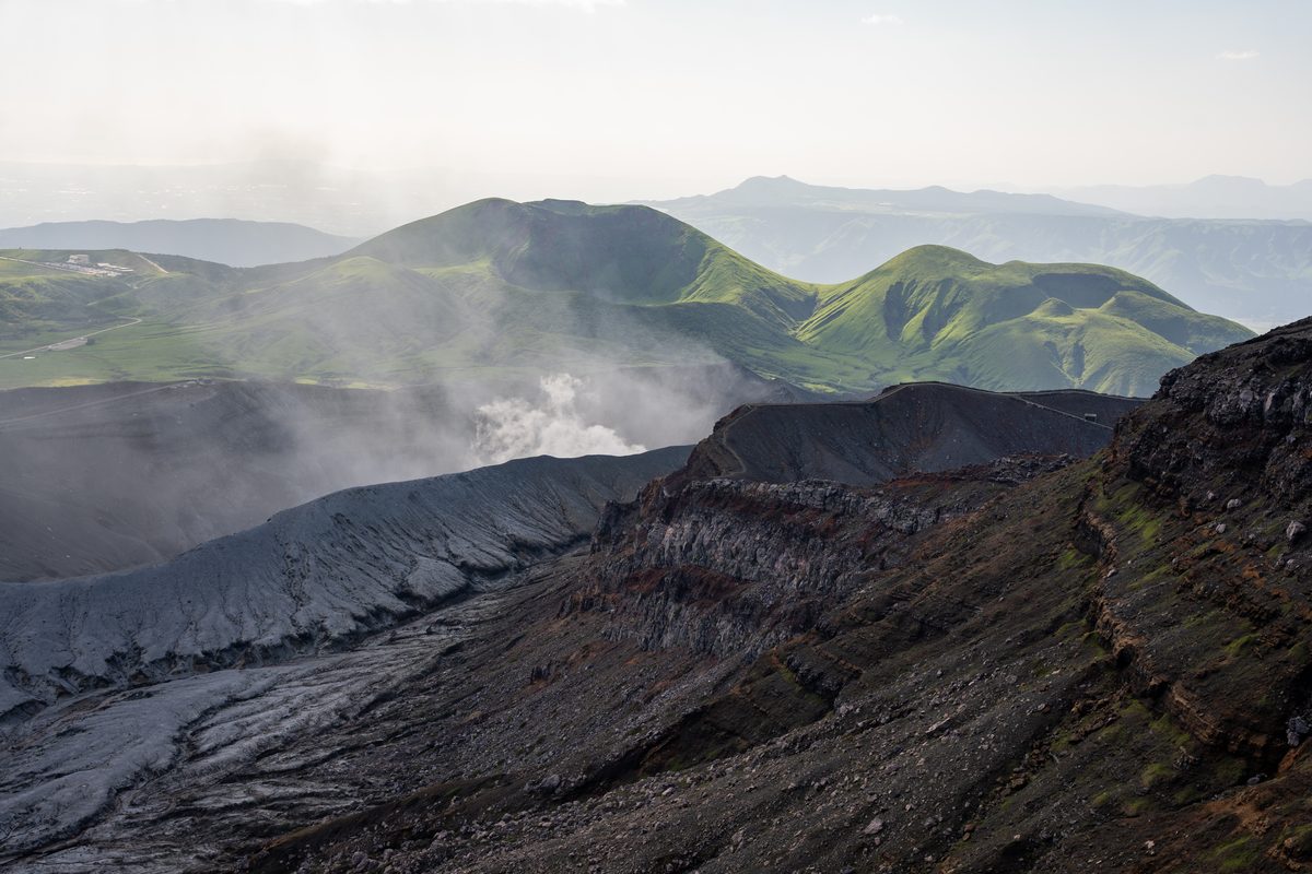 Contrast between volcanic ash grey and green grasslands at Mt Aso