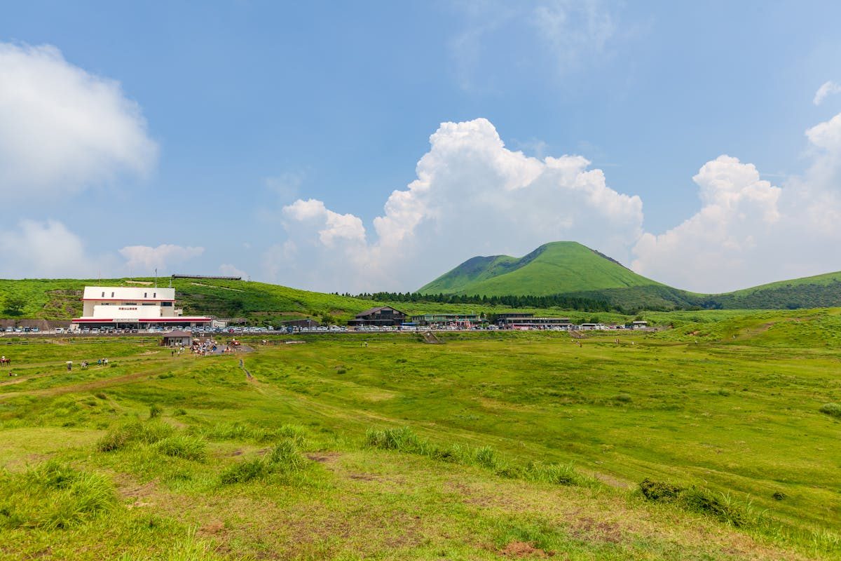 Rolling green hills of the Aso caldera under blue sky in Kyushu