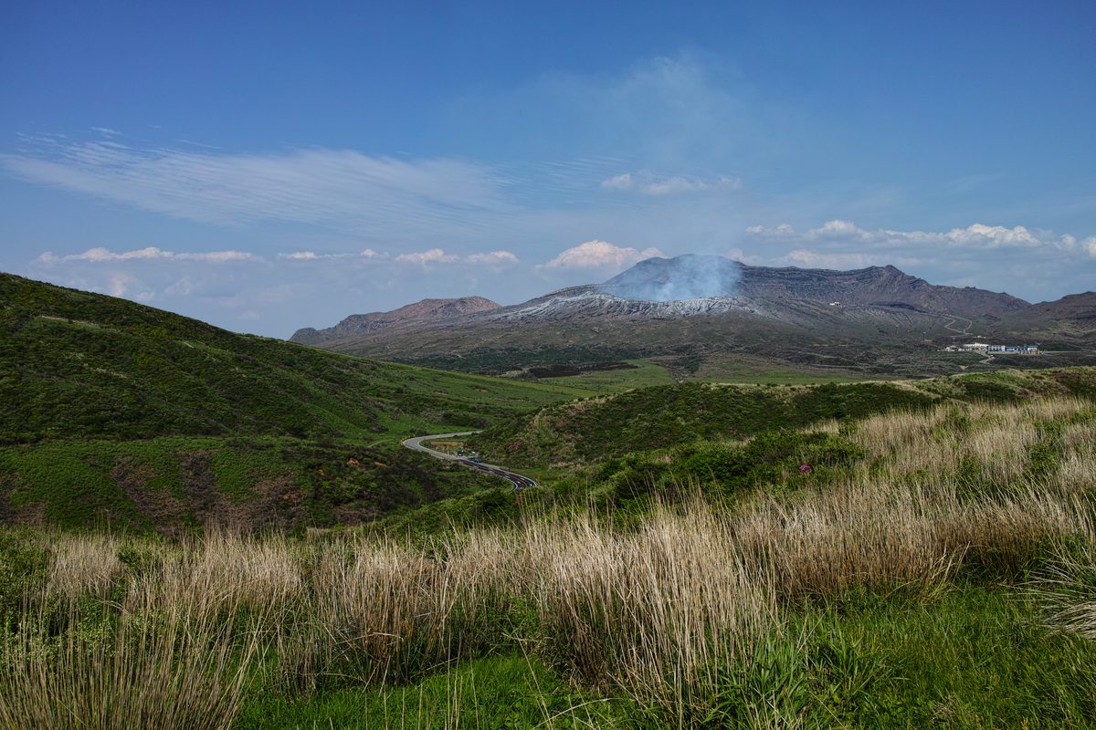 Active crater of Mt Aso volcano with steam and smoke rising