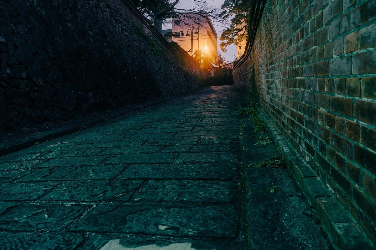 Hollander Slope cobblestone street lit by lanterns at night in Nagasaki