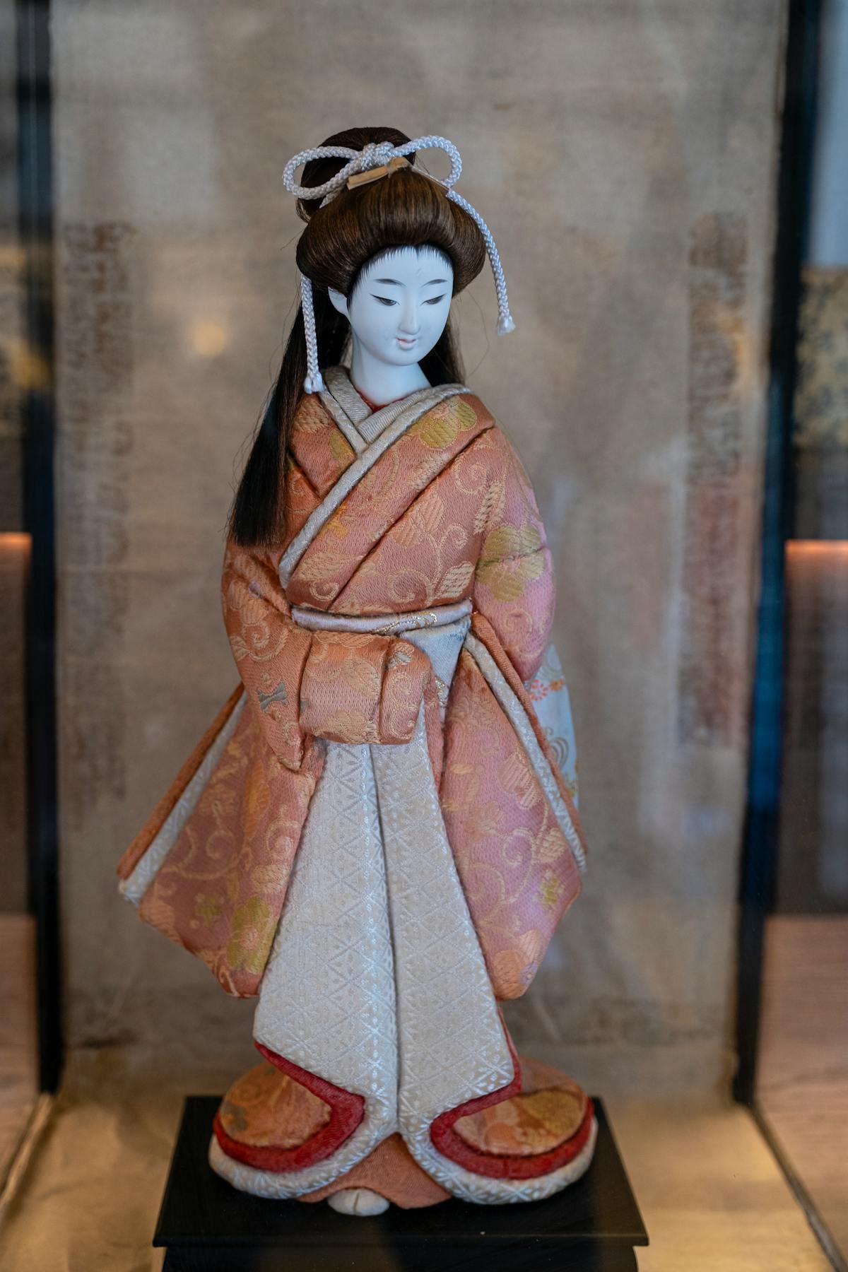 Traditional Japanese doll in geisha style with black hair and colourful kimono