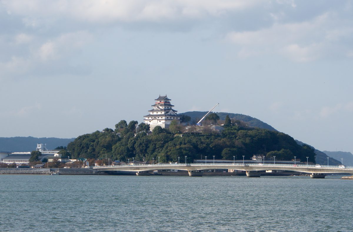 Wide view of Karatsu Castle on its hilltop with the city and sea below