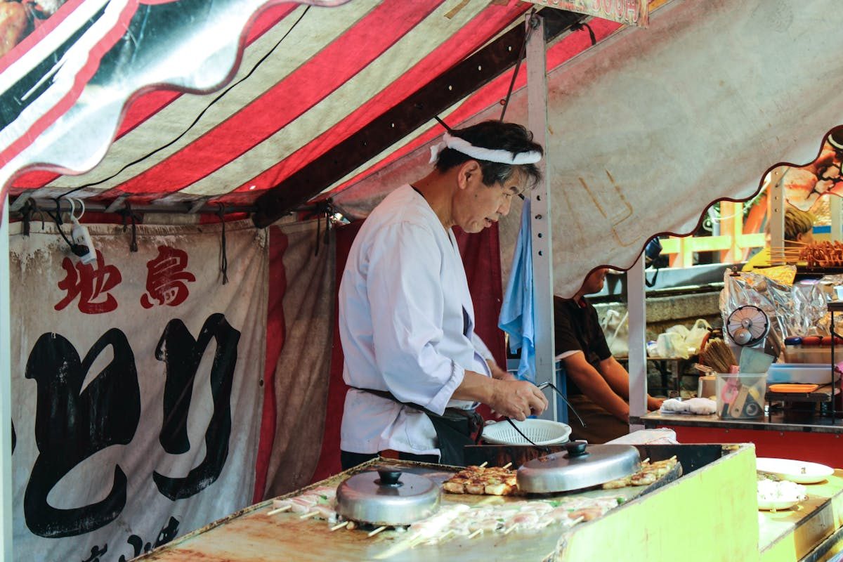 Street vendor cooking at an outdoor yatai food stall
