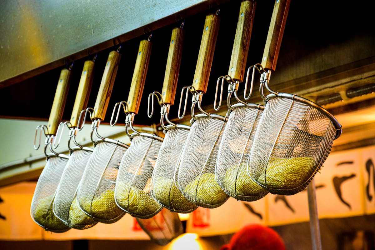 Noodle strainers hanging in a ramen restaurant kitchen