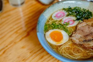 Close-up of a tonkotsu ramen bowl with noodles, egg, and toppings