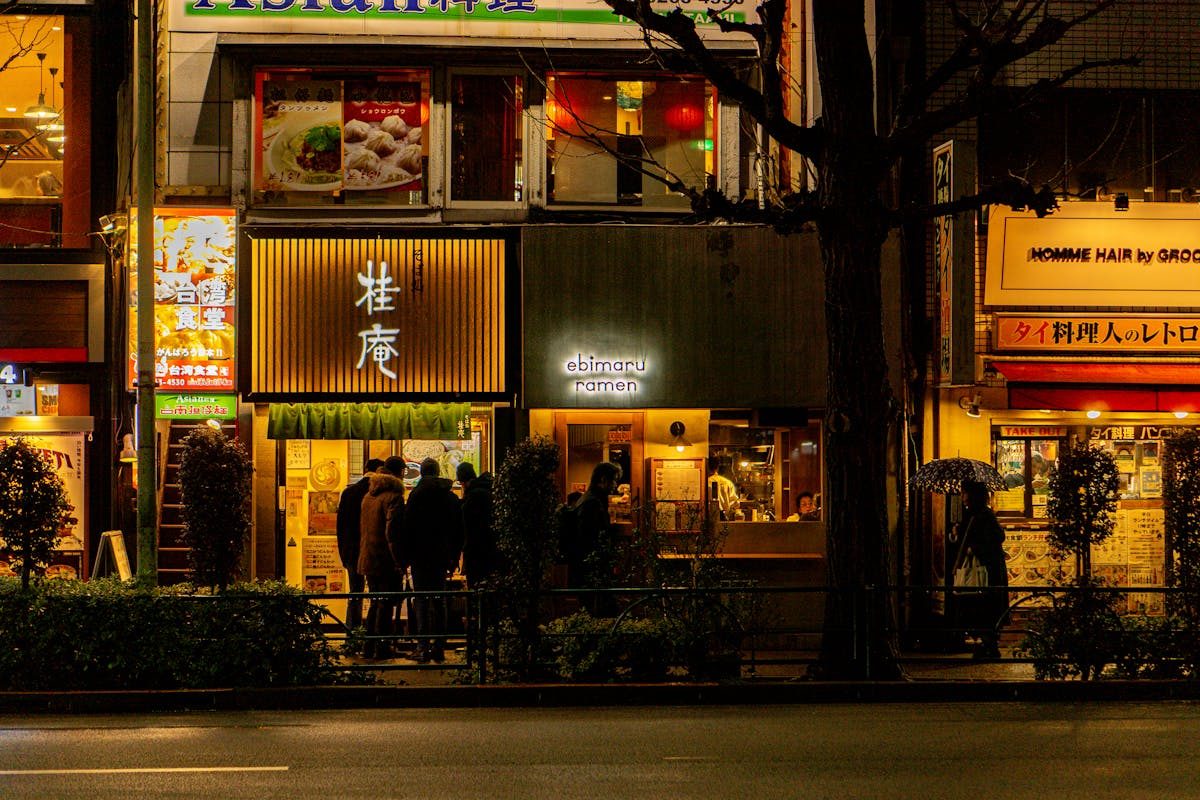 Illuminated ramen shops on a street in Japan at night