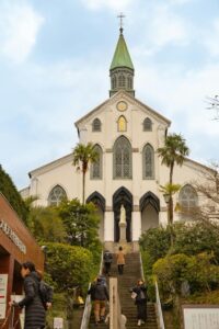 Oura Cathedral in Nagasaki with visitors walking up the stone steps