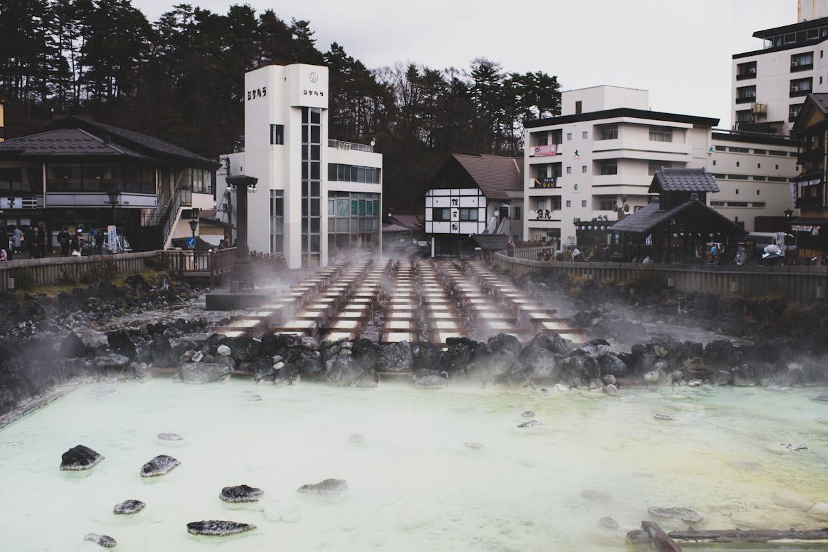 Steam rising from an onsen town with traditional buildings