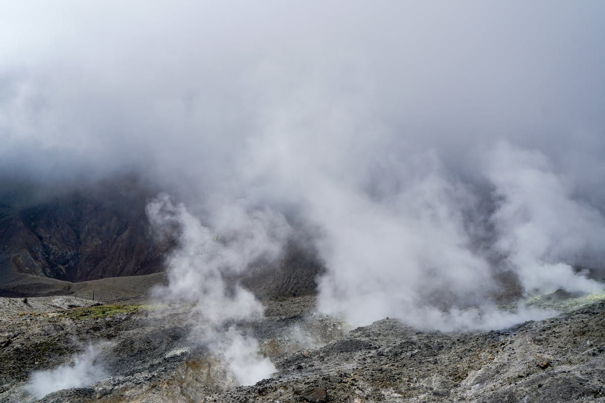 Steaming volcanic landscape shrouded in mist